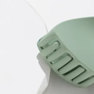 Large matte mint green cat ear hair claw clip shown on a minimalist white stone pedestal
