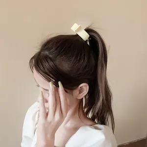 Elegant cream shark hair claw clip for high ponytail styling on brunette hair