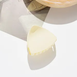Detailed view of cream triangle matte hair claw clip on minimalist background