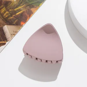 Close-up of a dusty pink matte shark hair clip with a stylish triangular design