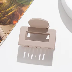 Détail macro d'une pince à cheveux carrée mate avec une texture élégante rose nude