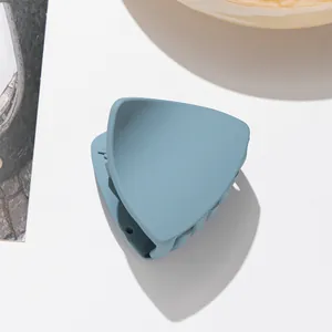 Detail view of a matte Morandi blue shark clip with a smooth frosted plastic texture