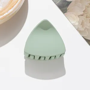 Macro detail of a matte mint green cat ear hair claw clip with non-slip interlocking teeth