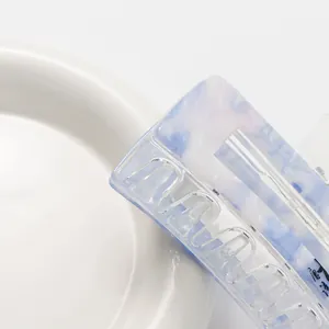Elegant blue and white marble pattern hair claw clip on a white ceramic plate