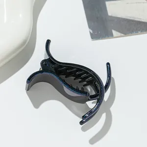 Macro shot of black shark hair clip with blue and purple shimmer glitter detail