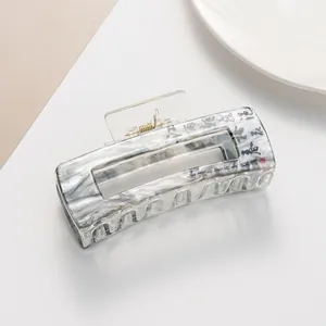 Macro detail of ink wash marble hair claw clip with Chinese calligraphy design