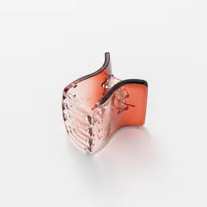 Detail view of a translucent amber gradient hair claw clip with strong metal spring