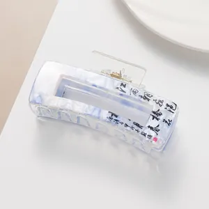 Close-up of rectangle acetate hair claw clip with marble texture and Chinese calligraphy