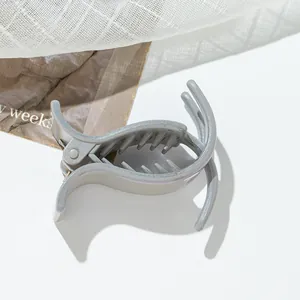 Detailed view of grey glitter shark hair claw clip with frosted texture on mesh background