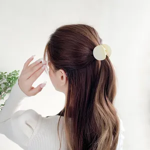 Matte beige round claw clip for women's half-up hairstyle on deep brown long hair