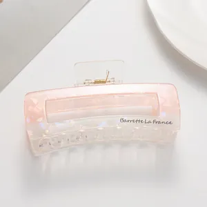 Macro shot of large pink marble acetate hair claw clip with Barrette La France lettering