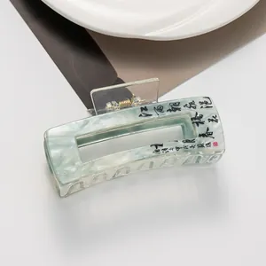 Detail of a large hair claw clip with Chinese calligraphy and marble texture
