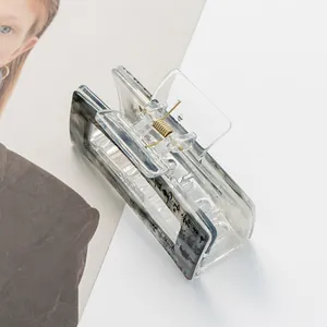 Detail of square acrylic hair claw with artistic Chinese ink calligraphy and gold spring