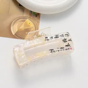 Detail of a white marble texture hair claw clip with black Chinese calligraphy art