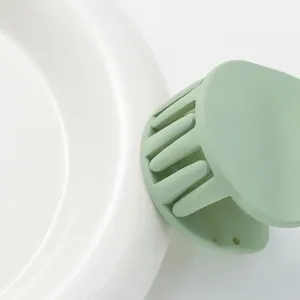 Matte light green circular hair claw clip for kids, minimalist hair accessory on white ceramic