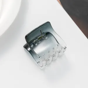 Close-up of a mini transparent gradient hair claw clip with a durable metal spring