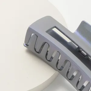 Iridescent dark grey rectangular hair claw clip with metallic shimmer on white stand