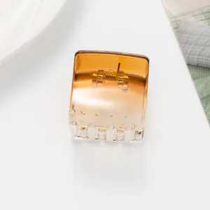 Detail view of a translucent amber gradient square hair claw clip with a strong metal spring