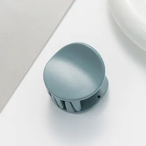 Detail view of small matte hair claw clip in morandi blue with smooth teeth texture