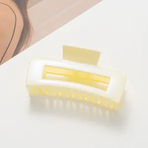 Top view of large matte cream rectangular claw clip with elegant hollow design