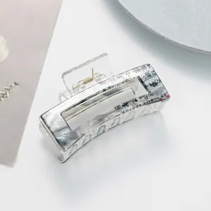Detail of translucent marble acetate hair claw with elegant black calligraphy