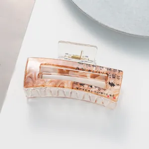 Macro detail of amber marble hair claw with Chinese calligraphy and red seal design