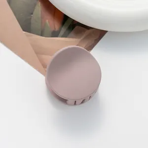 Macro view of matte mauve mini hair claw clip with smooth frosted finish texture
