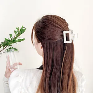 Pince à cheveux rectangulaire blanc crème minimaliste portée sur cheveux longs