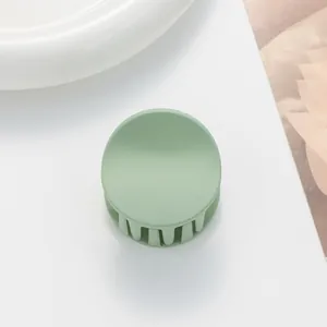 Detail of round matte Morandi green claw clip for thin hair with frosted texture