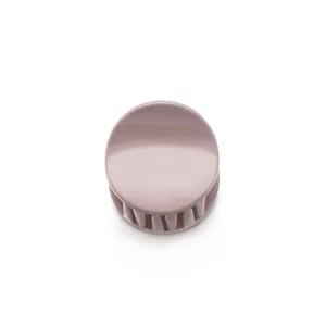 Macro detail of round matte hair claw clip in soft mauve with secure interlocking teeth