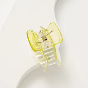 Vue détaillée d'une pince à cheveux jaune bonbon avec un ressort en métal doré