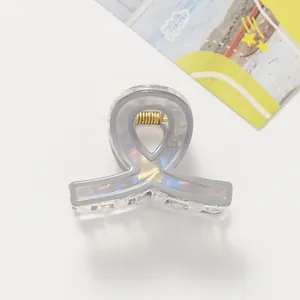 Dettaglio macro della molletta per capelli grigio traslucido con finitura iridescente