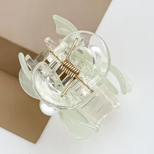 Details von hellgrünem Harz-Schmetterling-Haarclip mit Perle und goldener Feder
