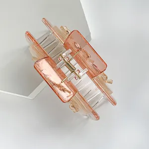 Eleganter quadratischer Haarklammer mit orangefarbenem Farbverlauf auf weißem Block