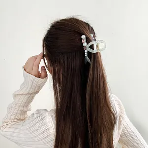 Pince à cheveux queue de sirène avec perles et strass sur cheveux bruns demi-attachés