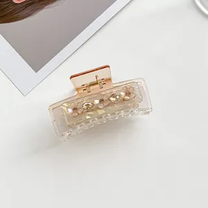 Detail view of transparent amber flower hair claw with white floral rhinestones decoration