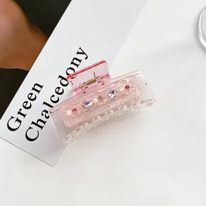 Close-up of pink translucent flower hair claw clip with rhinestones and gems