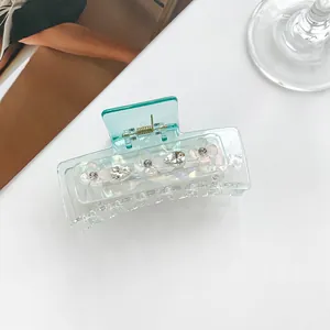 Detailopname van de lichtblauwe haarklem met witte bloemen en glanzende strass-steentjes