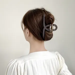 Detail of 13cm dark grey checkered hair claw clip for thick hair styling on model