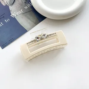Gros plan sur pince à cheveux rectangulaire beige ornée de strass en forme de cœur