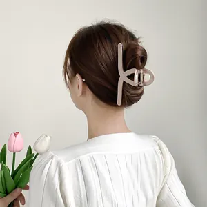 Detail of 13cm beige plaid shark hair claw clip showing grid pattern on a bun hairstyle