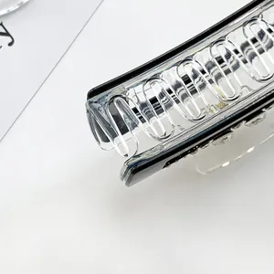 Macro shot of transparent rhinestone hair claw clip showing detailed teeth and spring mechanism