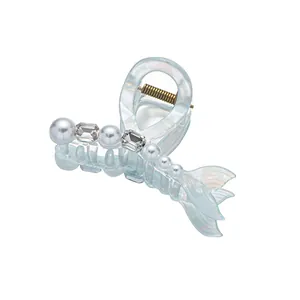 Pince à cheveux queue de sirène bleu iridescent avec perles et cristaux sur fond blanc