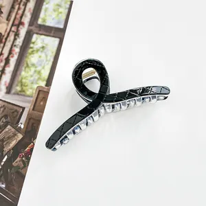 Detail view of 13cm black claw clip with quilted texture and golden metal spring