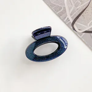 Detailansicht der ovalen Glitzer-Haarklammer mit dunkelblau funkelndem Finish und klassischem Griff