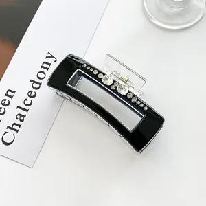 Macro shot of rectangular black hair claw clip featuring sparkling inlaid rhinestones