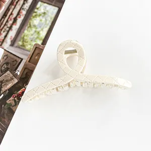 Detailed macro view of 13cm beige shark clip with elegant quilted texture and metal spring