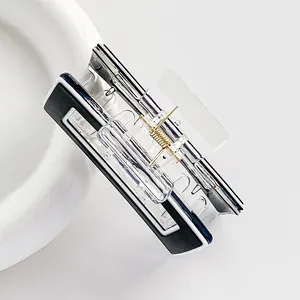 Detail of a square acrylic hair claw clip with black and white contrast and gold spring