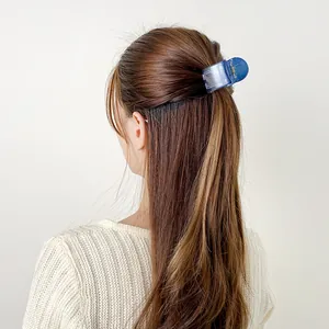 Blue translucent shark hair claw clip for high ponytail styling on a fashion model