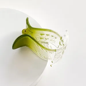 Detail showing the inner 'MADE IN KOREA' mark and interlocking teeth of the green hair claw